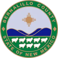 Bernalillo County seal with Zia sun symbol, blue hills, and white sheep