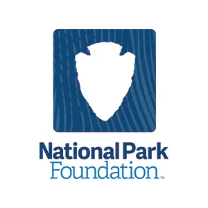National Park Foundation logo with white arrowhead on blue woodgrain background